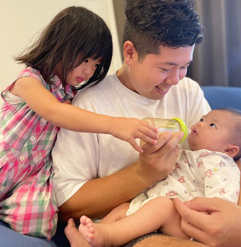 赤ちゃんにミルクをあげる蓮沼桜雲さんの写真